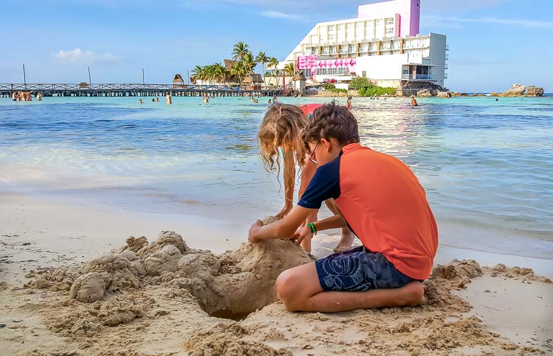 kids playing in the sand in Isla Mujeres Mexico
