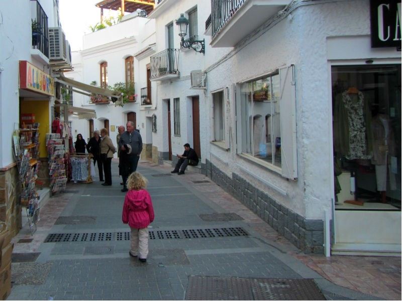 Little girl walking through the white village of Nerja