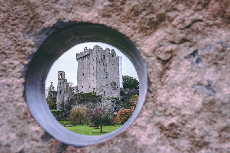Blarney Castle in Ireland framed by stone peephole