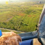 Ready to land hot air balloon view from basket with truck below