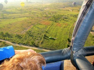 Ready to land hot air balloon view from basket with truck below