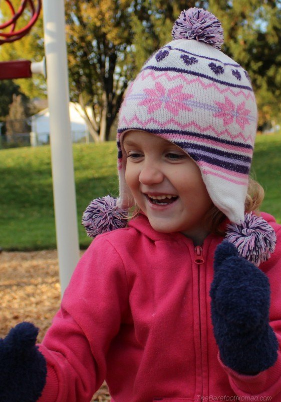 Little girl in touque smiling in fall