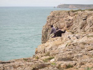 Fishermen standing precariously on the cliffs at Sagres Point