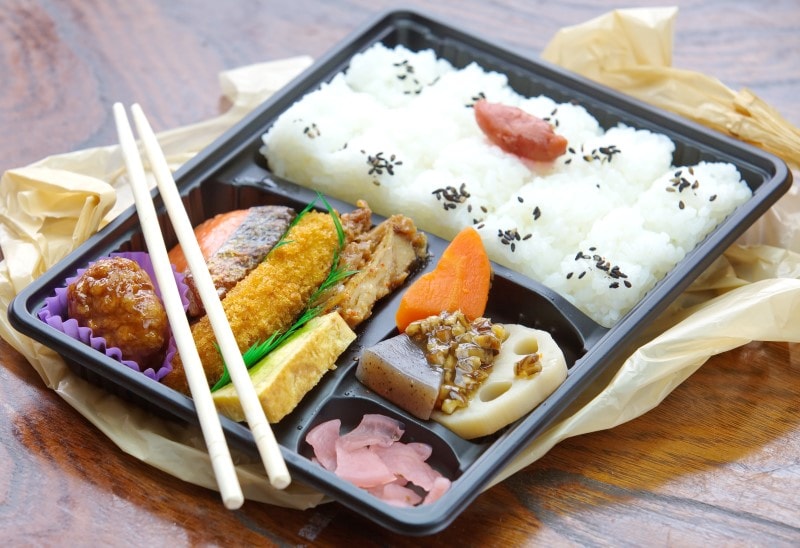 Japan Ekiben Bento box full of rice, meats and wooden chopsticks