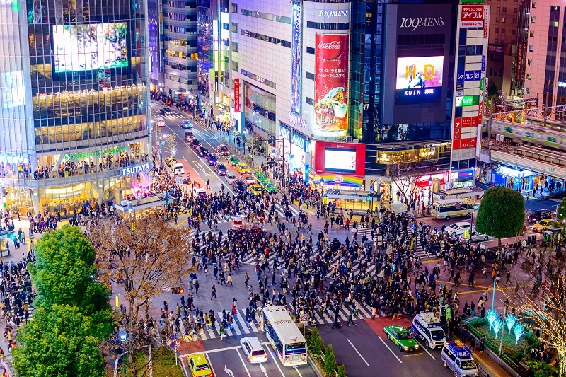 Pedestrians cross at Shibuya Crossing. It is one of the world's most famous scramble crosswalks in one of Toyko's most interesting neighbourhoods.