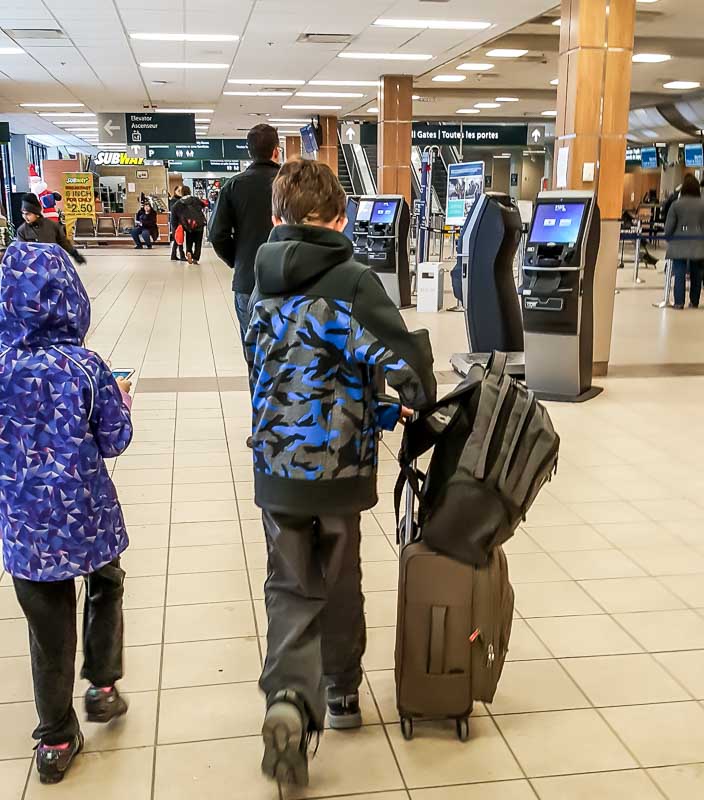 Our 11 year old with his luggage in the airport