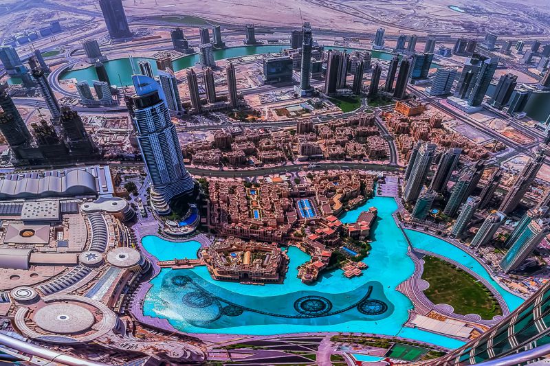 View from the Burj Kalifa looking down on Dubai with skyscrapers and a very big and blue pool