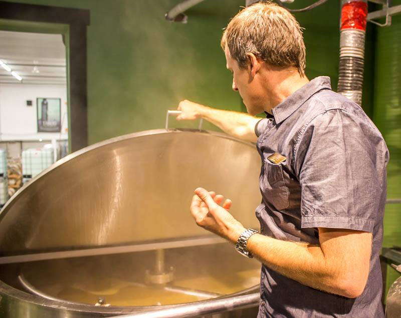 Okanagan Spirits Vernon CEO Tyler Dyck checking on fermentation