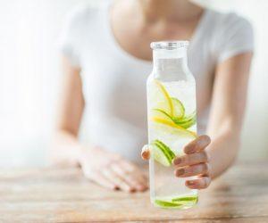 Holding a glass of lemon water