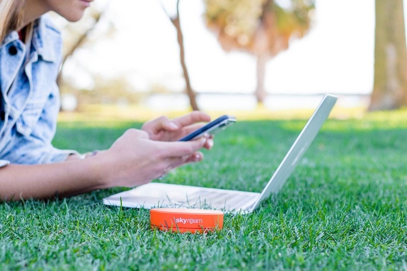 skyroam solis portable wifi with laptop in the grass