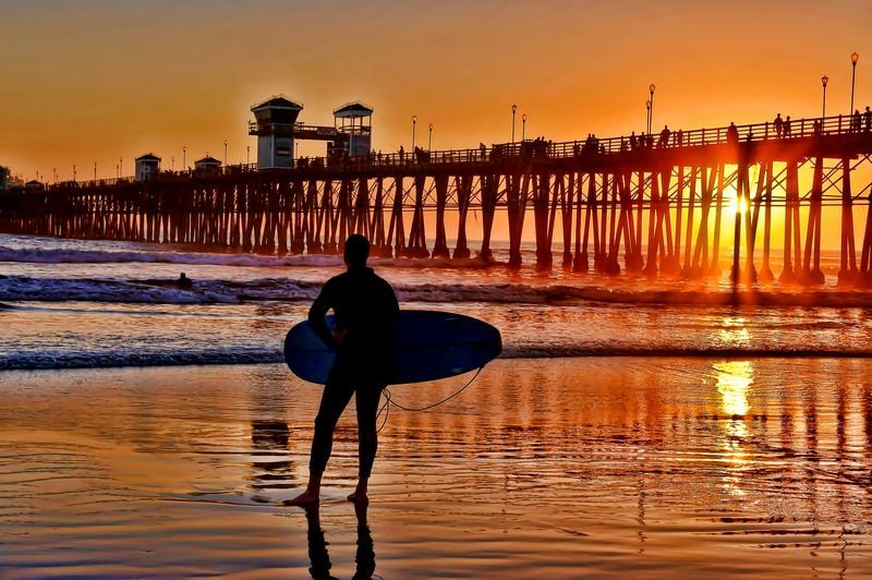 Silhouetted surfer at sunset in Oceanside California weekend getaway from Los Angeles