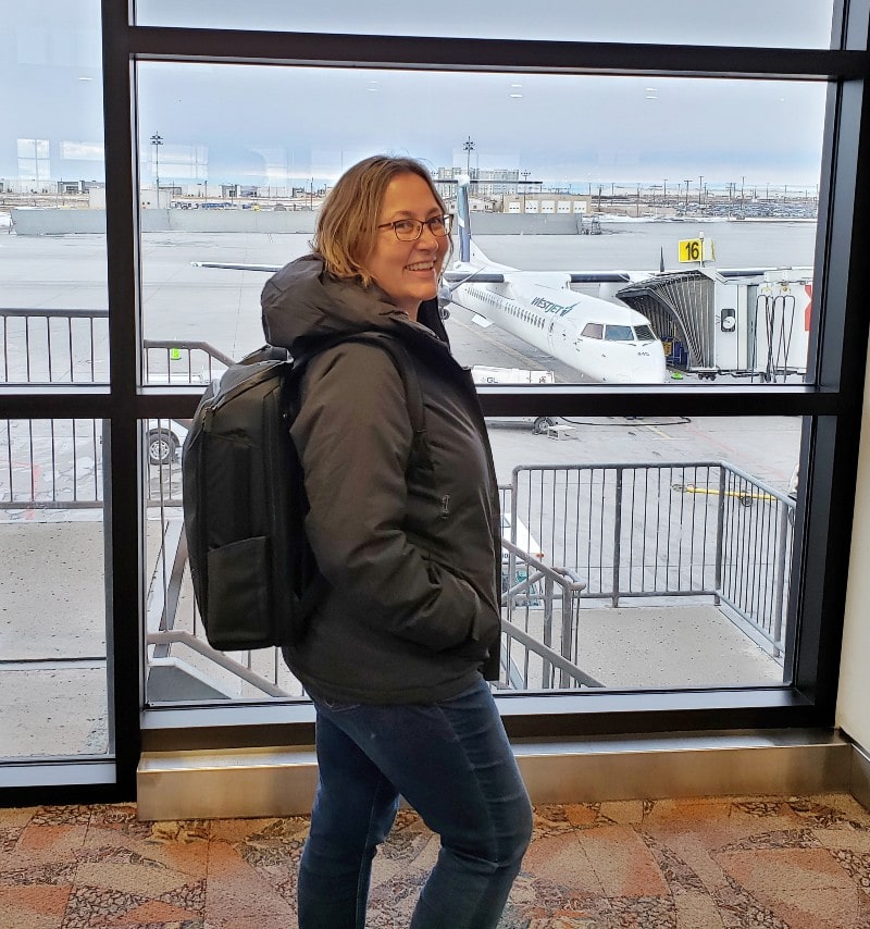 Vista lateral de la mochila Nomatic sobre la mujer en el aeropuerto