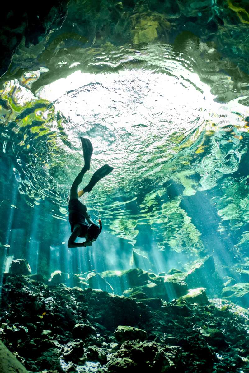 Gran Cenote Tulum Mexico a Woman swimming underwater