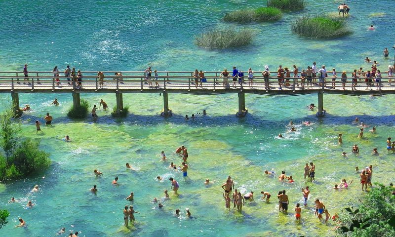 People swimming by a wooden bridge Krka National Park Croatia 