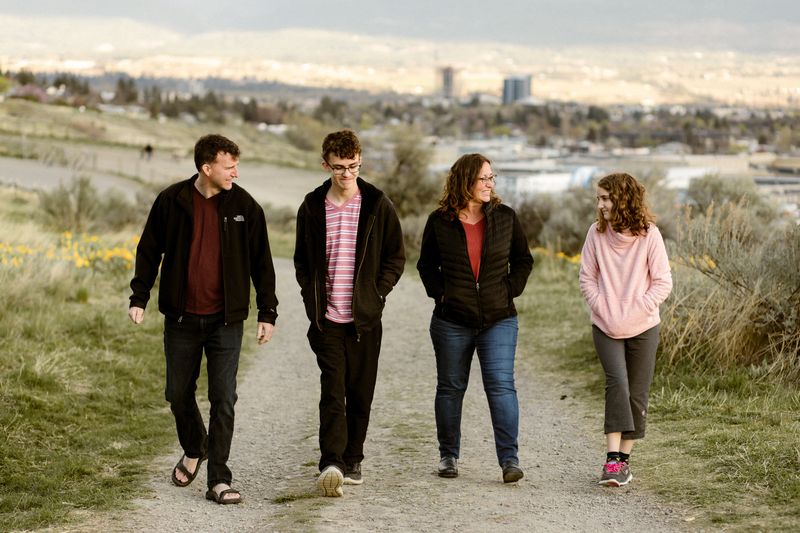 The Barefoot Nomad family walking in Kelowna with downtown in the background