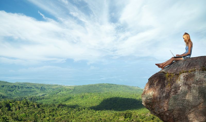 girl using mobile phone on mountaintop