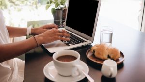 woman with laptop sitting in café