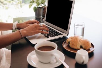 woman with laptop sitting in café