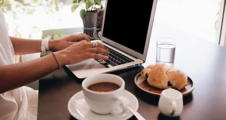 woman student with laptop sitting in cafe