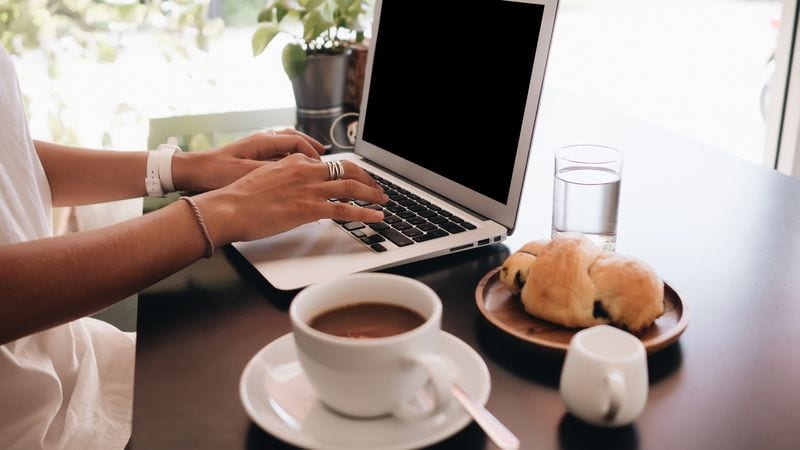 cybersecurity awareness on laptop - woman with laptop sitting in cafe