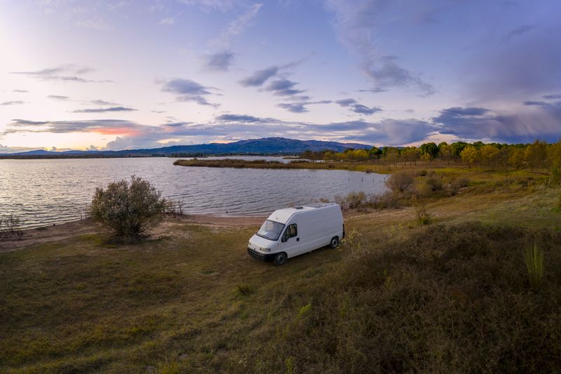 camping-car avec panneau solaire au bord d'un lac