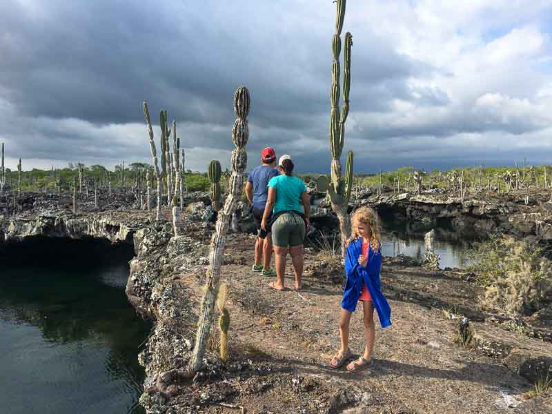 Isabela Island Los Tuneles girl and lava arches and cacti