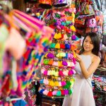 Best Thailand Souvenirs Young woman shopping at street market