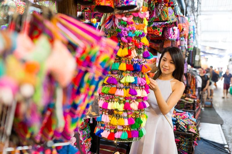 Best Thailand Souvenirs Young woman shopping at street market 