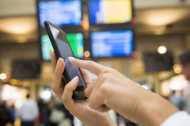 Close up of hands woman using her cell phone in station, background station