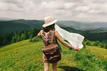 How to travel more young woman walking with hat and backpack on mountaintop