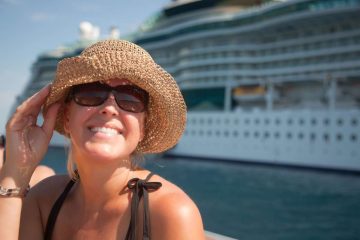 A happy woman in a hat near cruise ship