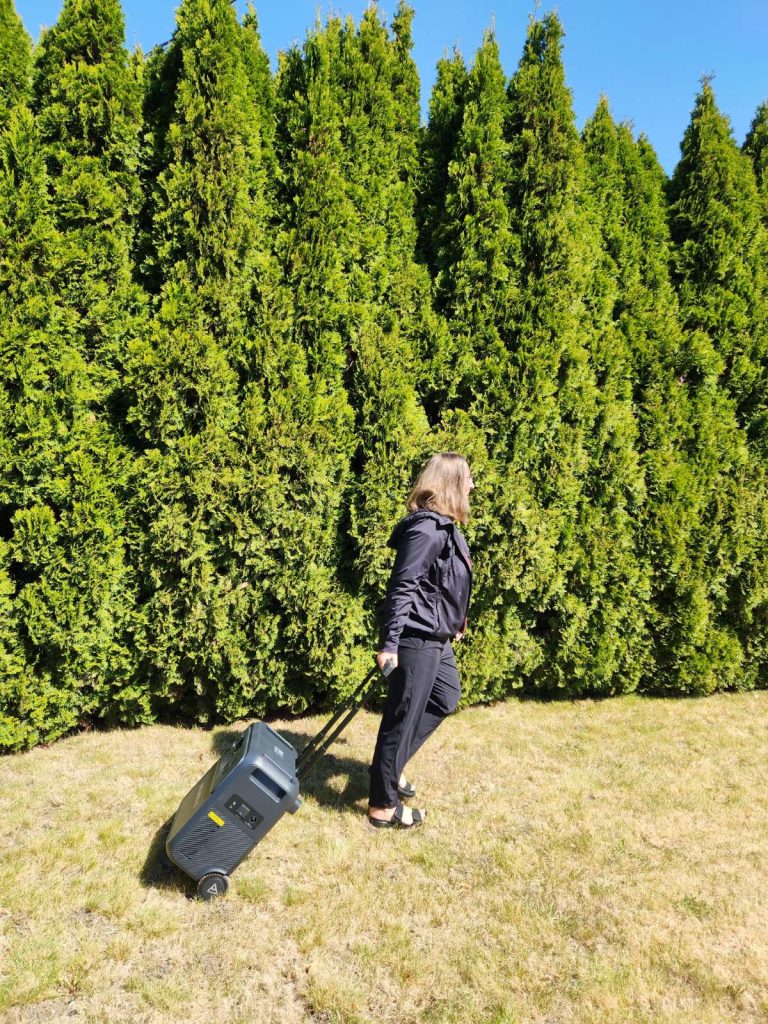 BLUETTI Elite 400 on grass pulled by handle by woman