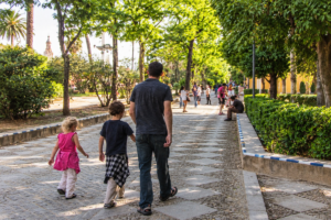 Kosman family walking along a leafy street in Seville