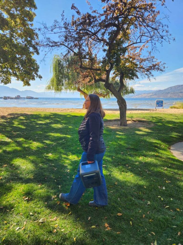 woman carrying BLUETTI Elite 100 Mini in park by handle vertical